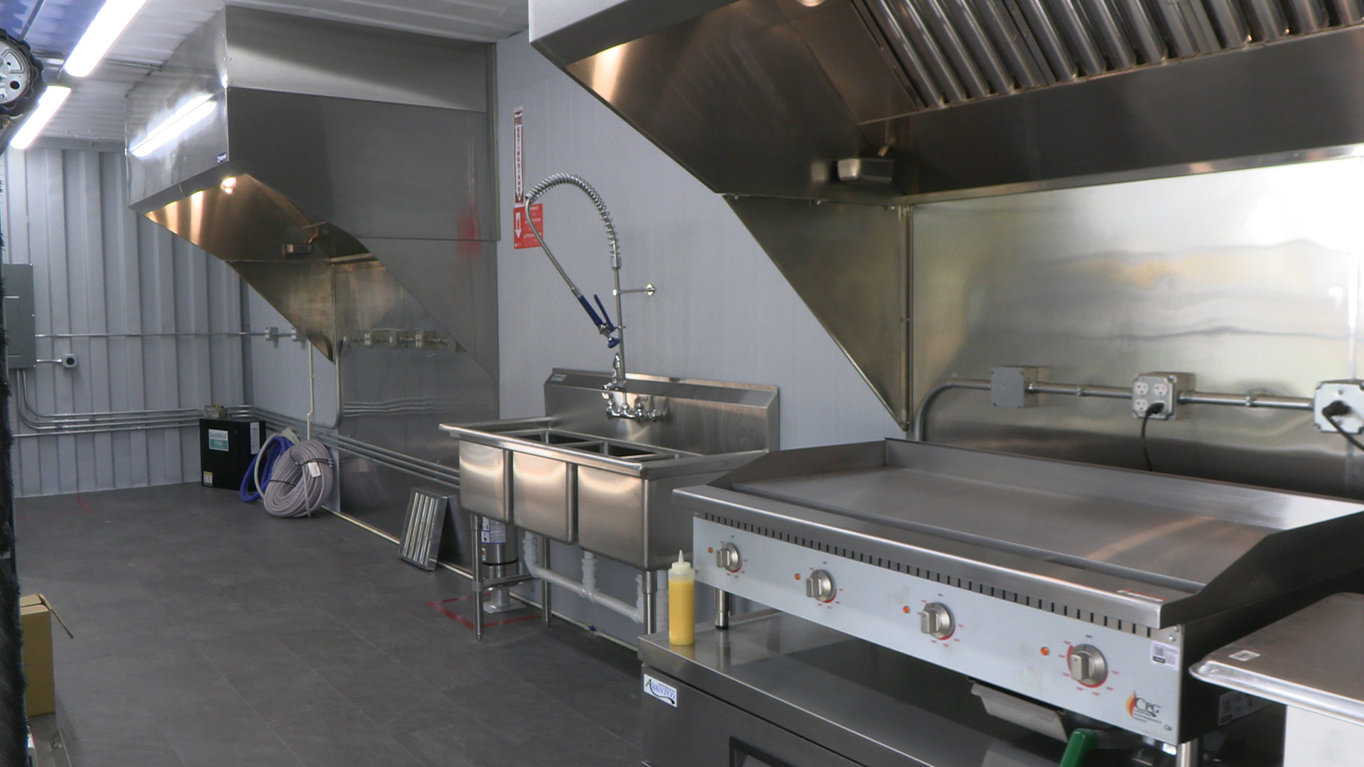 Test kitchen with commercial hoods, sink and griddle at the Research & Training Center